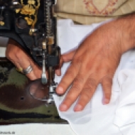 Beim Schneider wird schnell der Rand des Stoffes umgenäht, damit sich der Schal nicht gleich auflöst.
